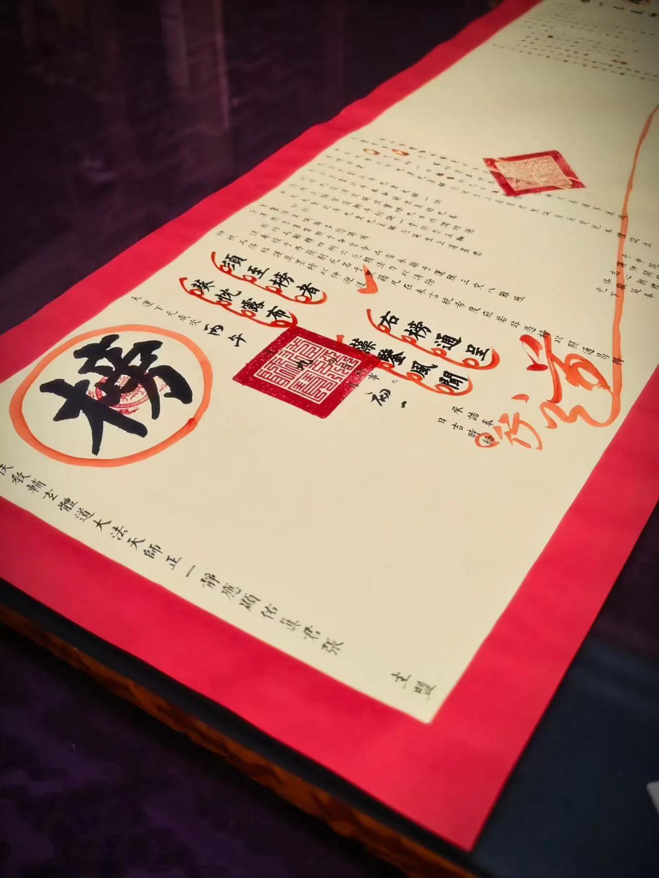 Ritual writing in black ink with large vermilion seal impressions on cream paper