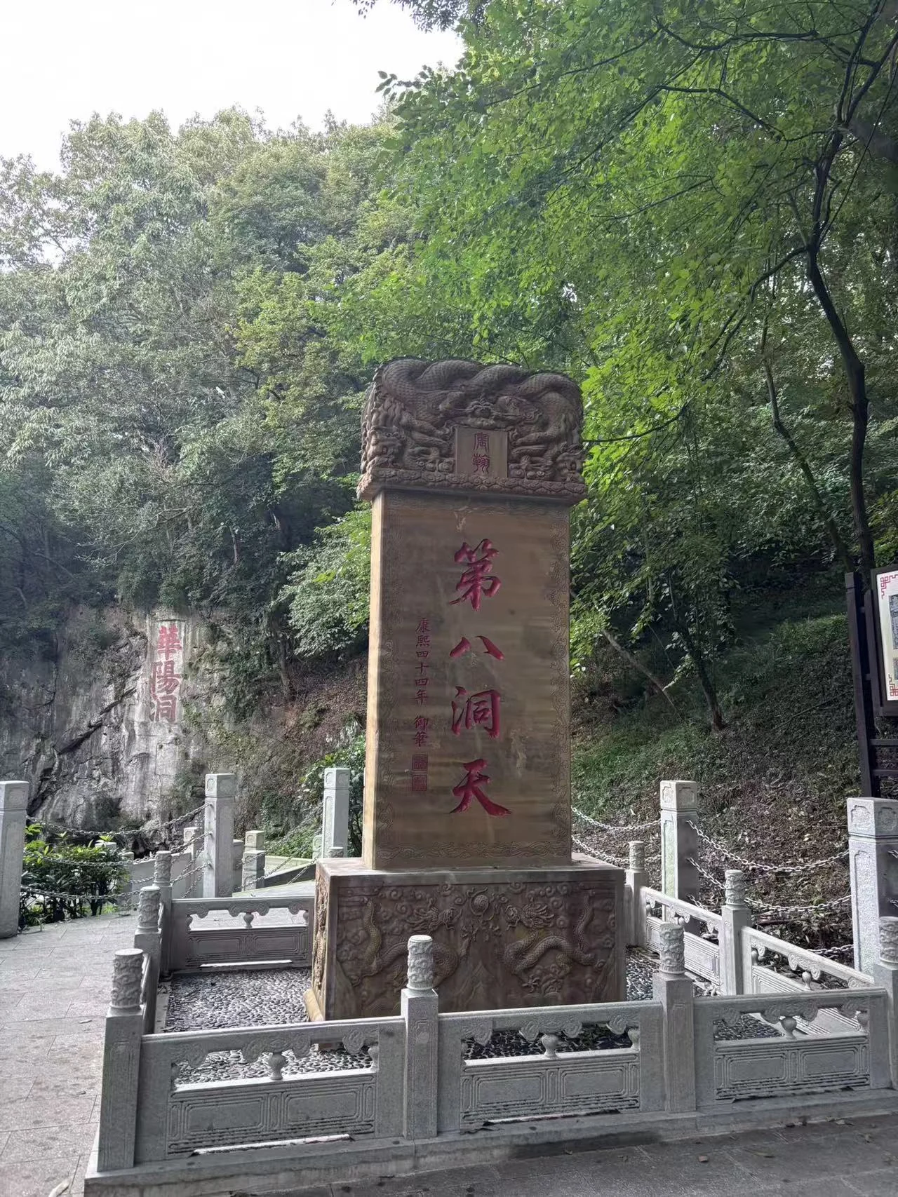 Stone marker inscribed Eighth Grotto Heaven beside a wooded path