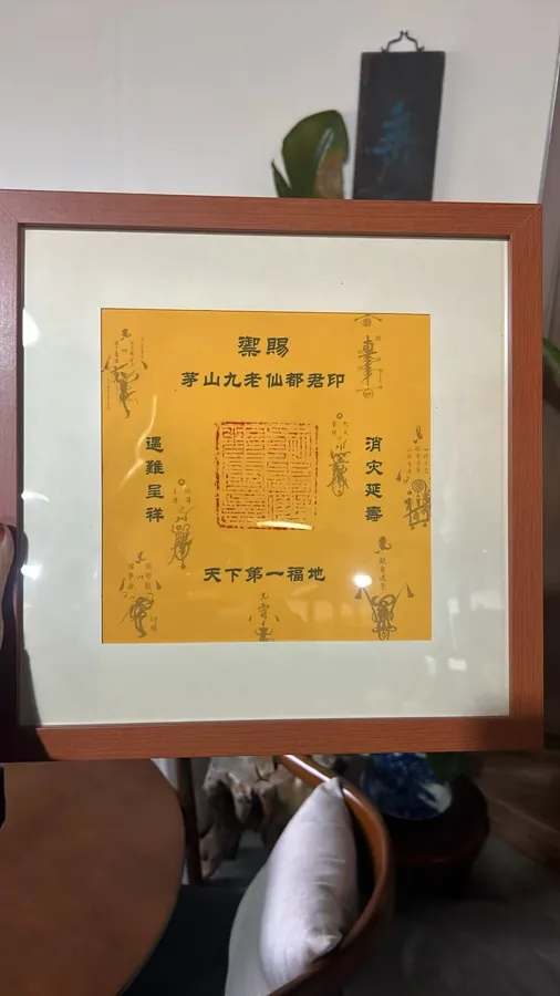 Framed yellow sheet with a red seal impression at its centre.