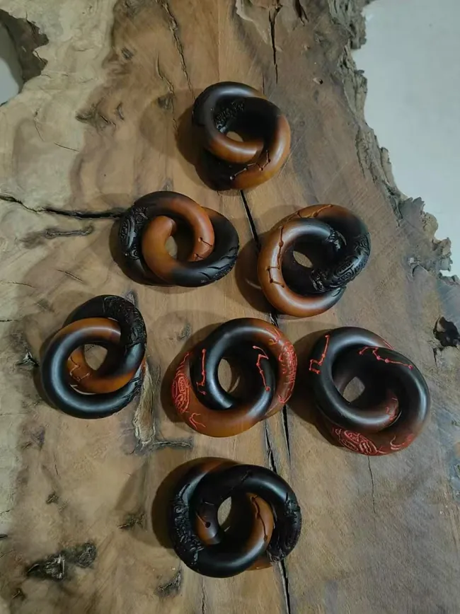 A group of dark ring-shaped ornaments with curling forms.