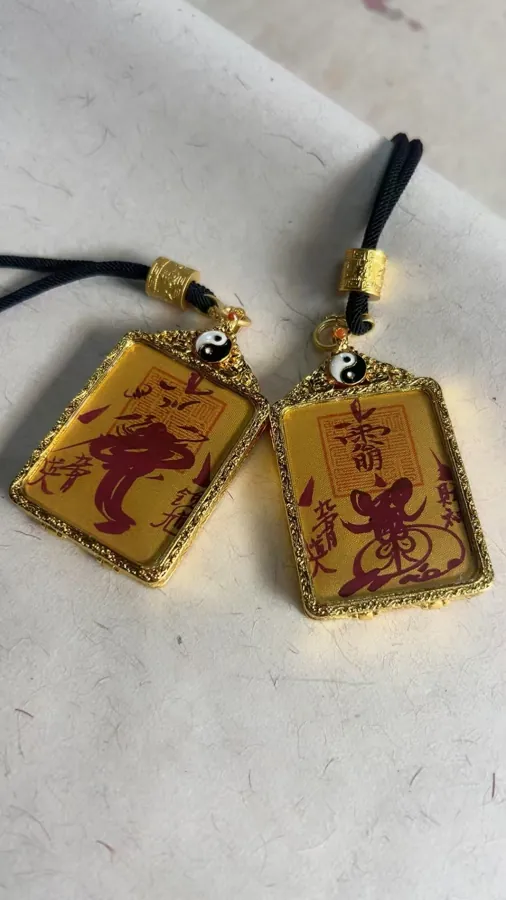 Two rectangular pendants with large talismanic signs and small yin-yang details.