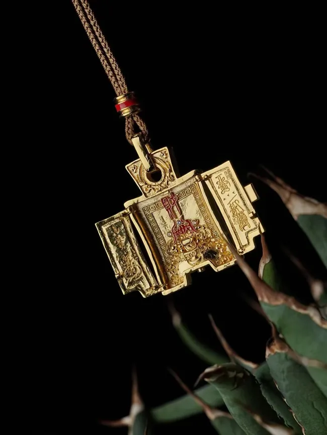 An open hinged pendant revealing a small devotional figure.