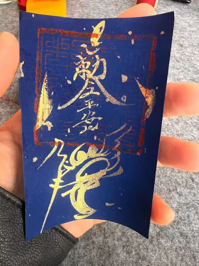 Light-coloured talismanic strokes on a blue sheet.