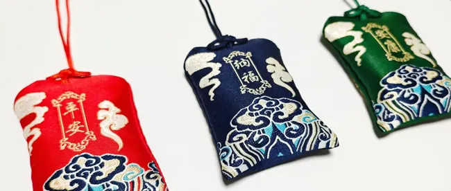 Three embroidered pouches in red, blue and green.
