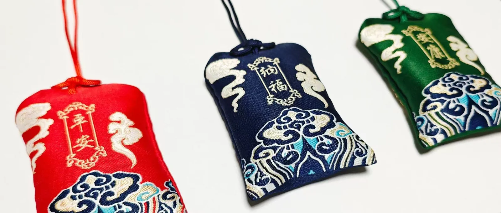 Red blue and green embroidered drawstring pouches with talismanic motifs