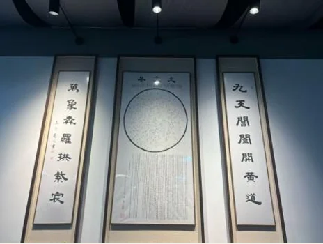 Three framed calligraphic panels on display, with a circular composition in the centre